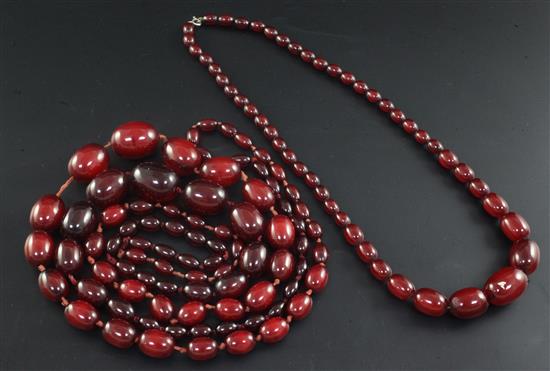 Two single strand red simulated amber bead necklaces, largest 158cm.